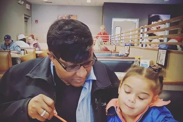 A mentor working through a book with a young student
