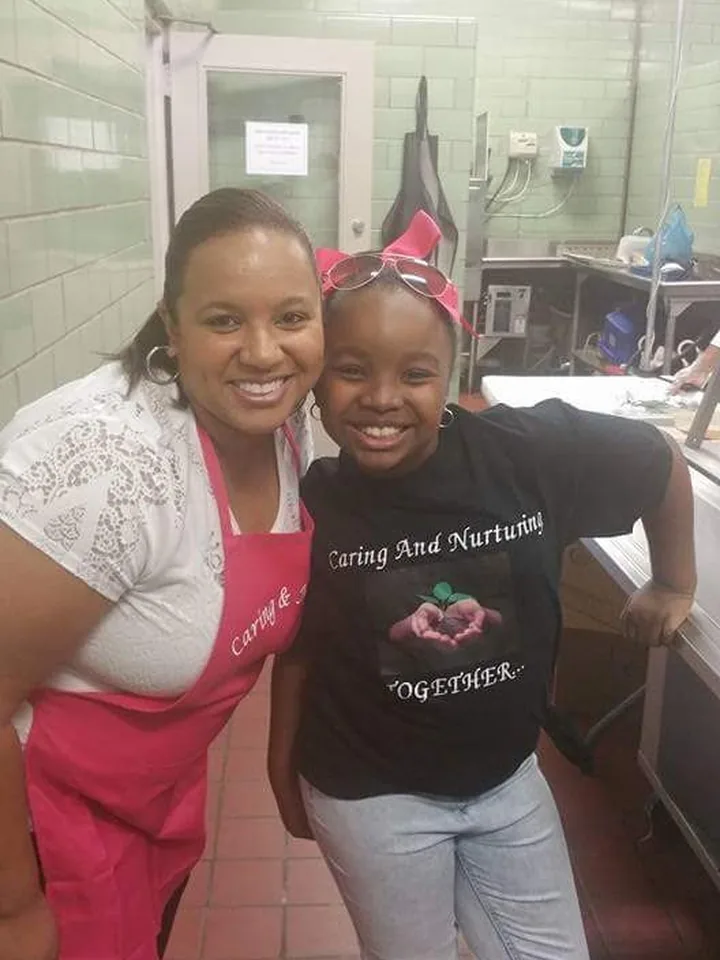 Two volunteers in Caring And Nurturing shirts at an event