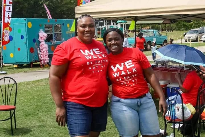 Two volunteers in matching shirts at a C.A.N. outdoor event
